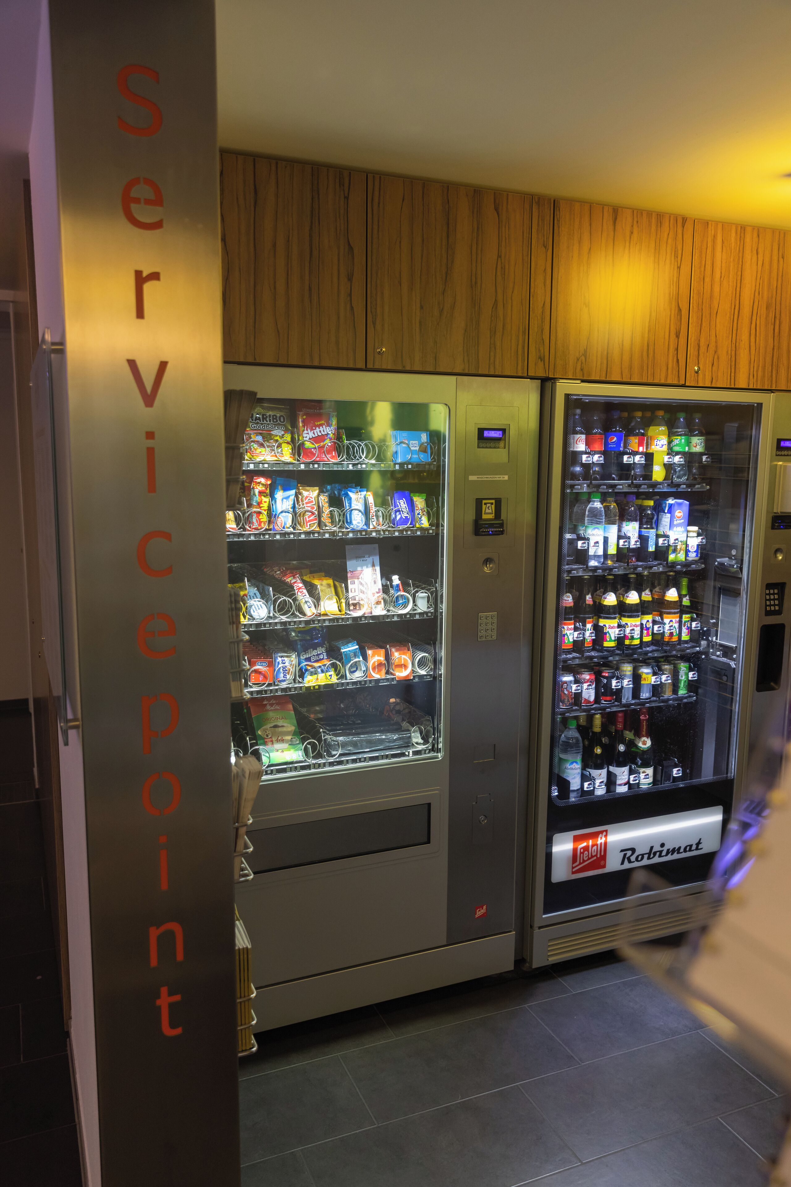 Ein Automaten mit verschiedenen Snacks und Getränken, beschriftet mit 'Servicepoint'.