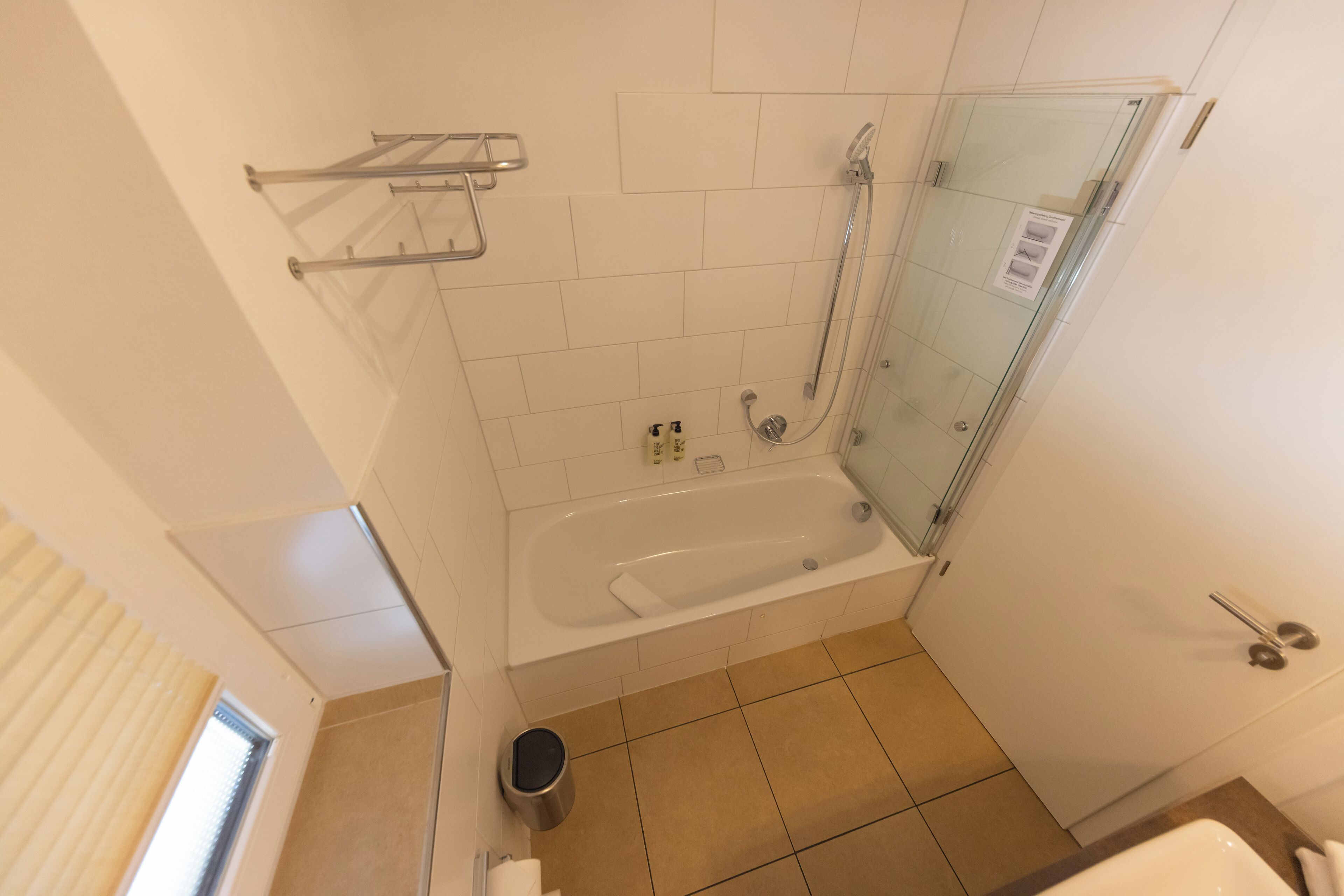 Une salle de bain avec une douche à parois de verre, une baignoire et des toilettes.