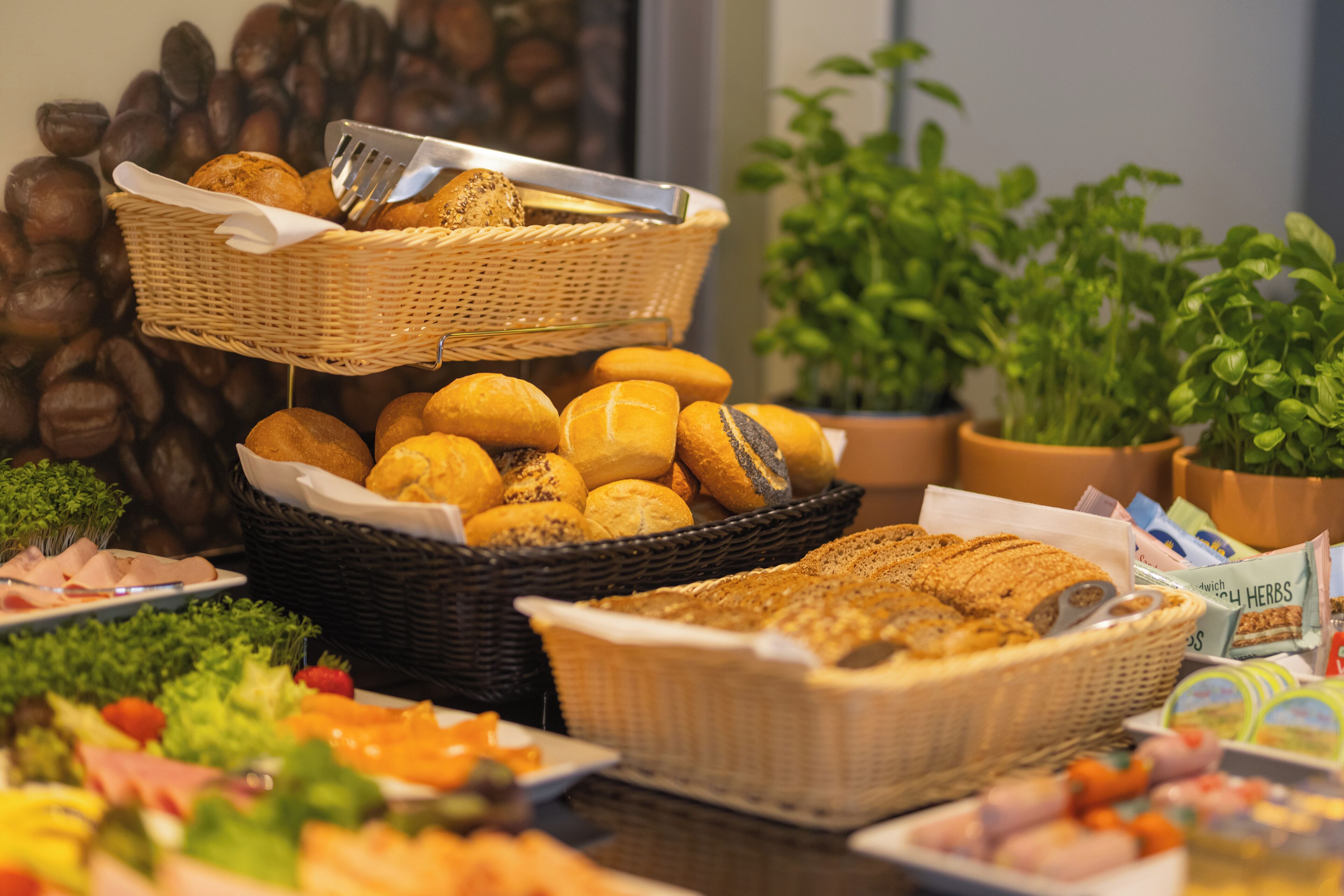 Un buffet proposant une variété de plats, notamment du pain, des pâtisseries et des salades.