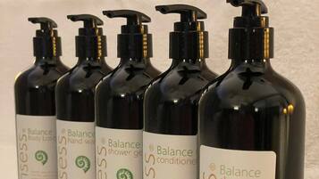 A row of black bottles with pump dispensers, each labeled 'Balance' and 'shampoo'.