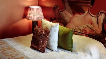 A bed with a decorative pillow, a lamp, and a painting on the wall.