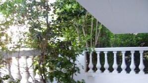 A white wall with a decorative balustrade and a potted plant. - Ninetta's Studios (Poros)