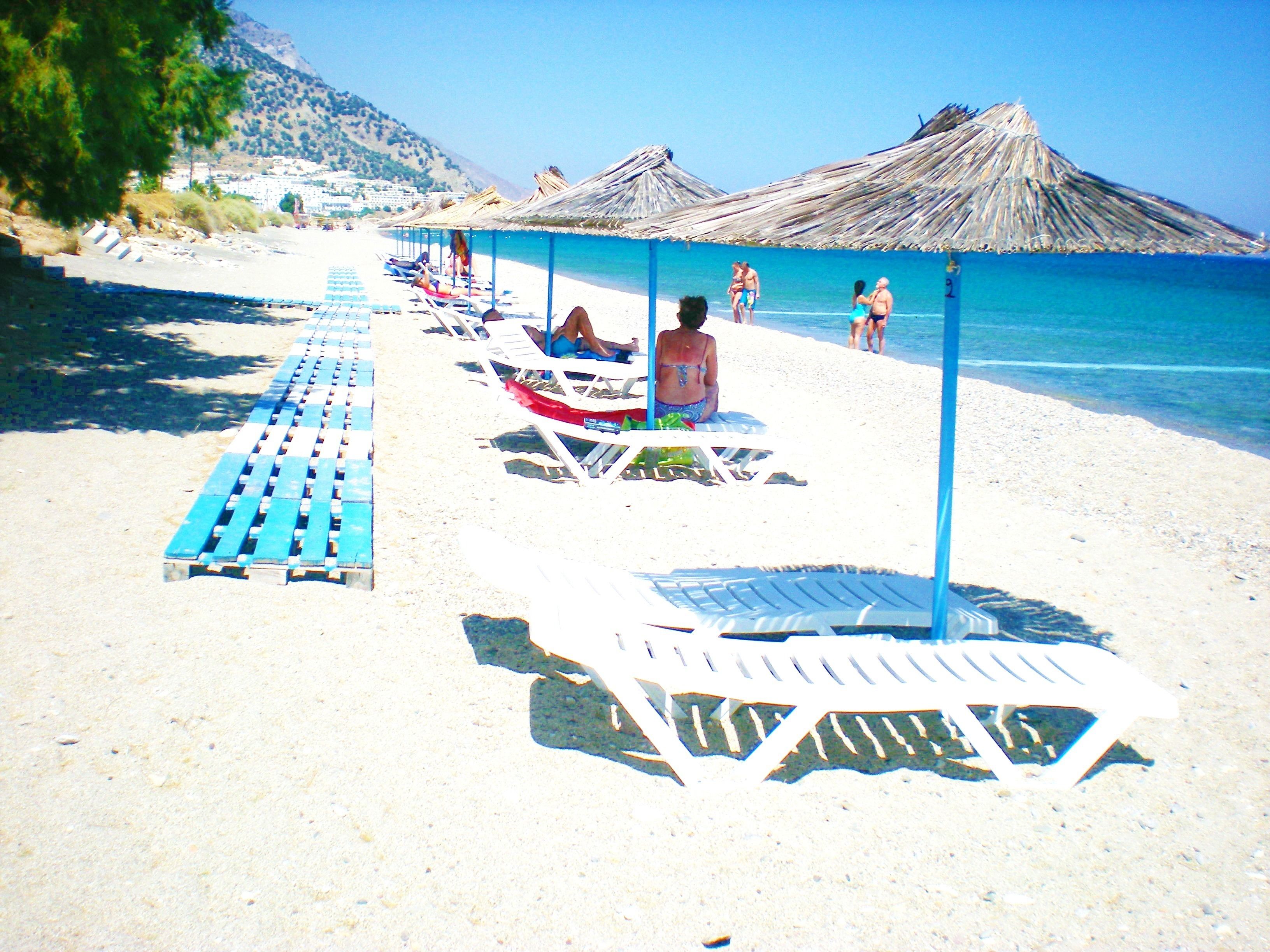 Gần bãi biển, ghế dài tắm nắng, dù trên bãi biển, khăn tắm biển 