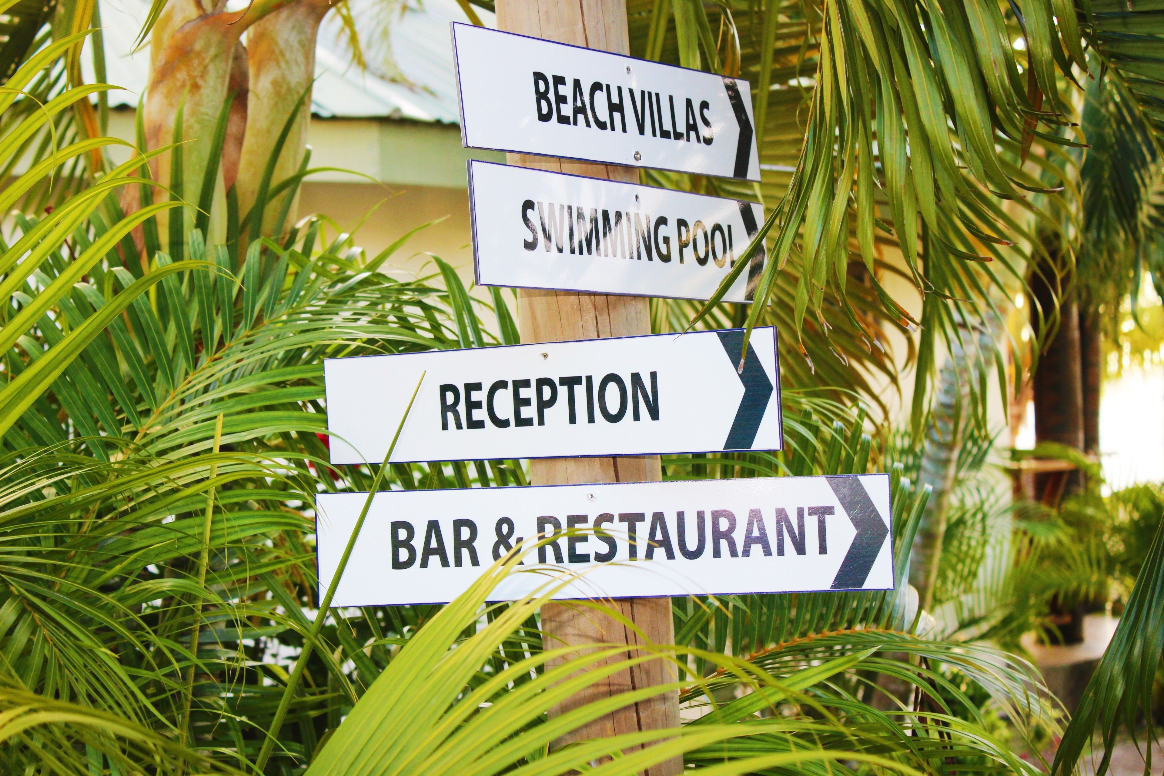 Beschilderung für Strandvillen, Schwimmbad, Rezeption und Bar & Restaurant.