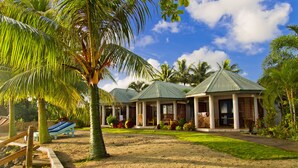 A resort with multiple buildings, palm trees, and a sandy landscape. - Le Uaina Beach Resort (Faleapuna)