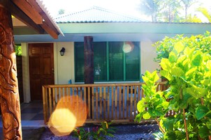 Una casa con porche de madera, un ventanal grande y una puerta.