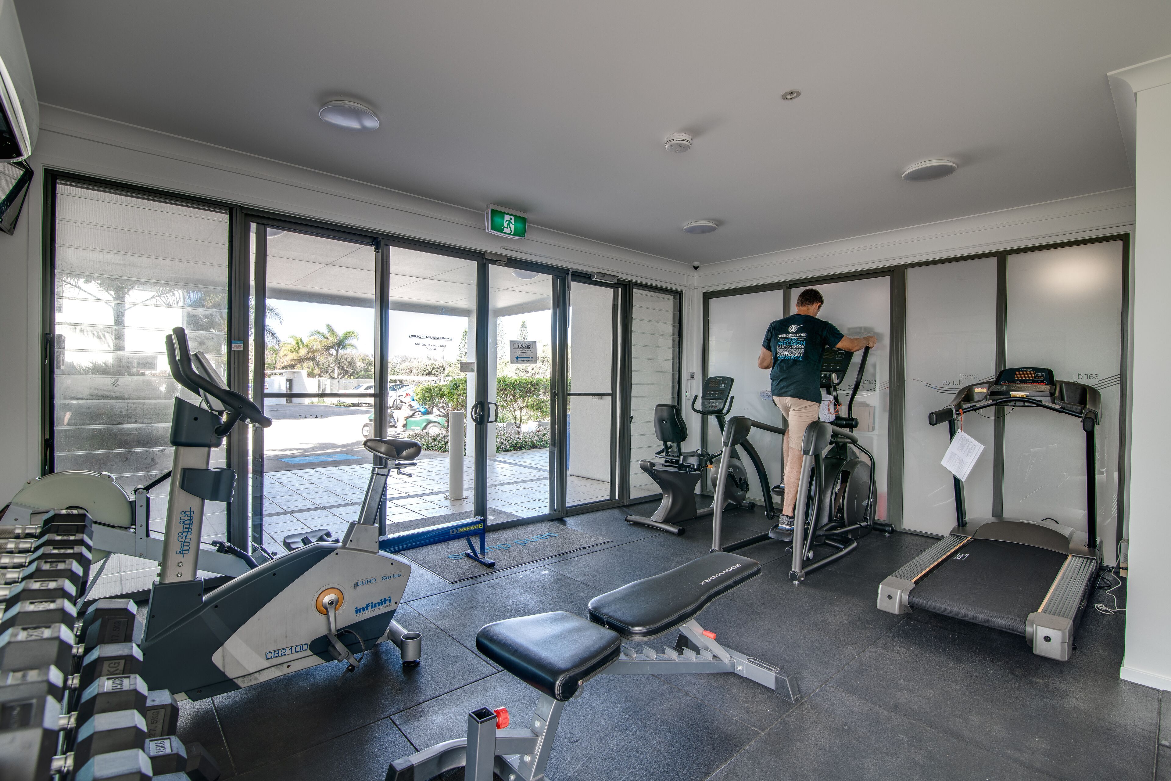 A gym with treadmills, elliptical machines, and weight benches.