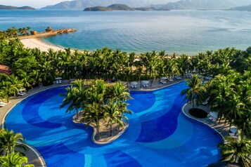 Una piscina al aire libre, sombrillas, tumbonas