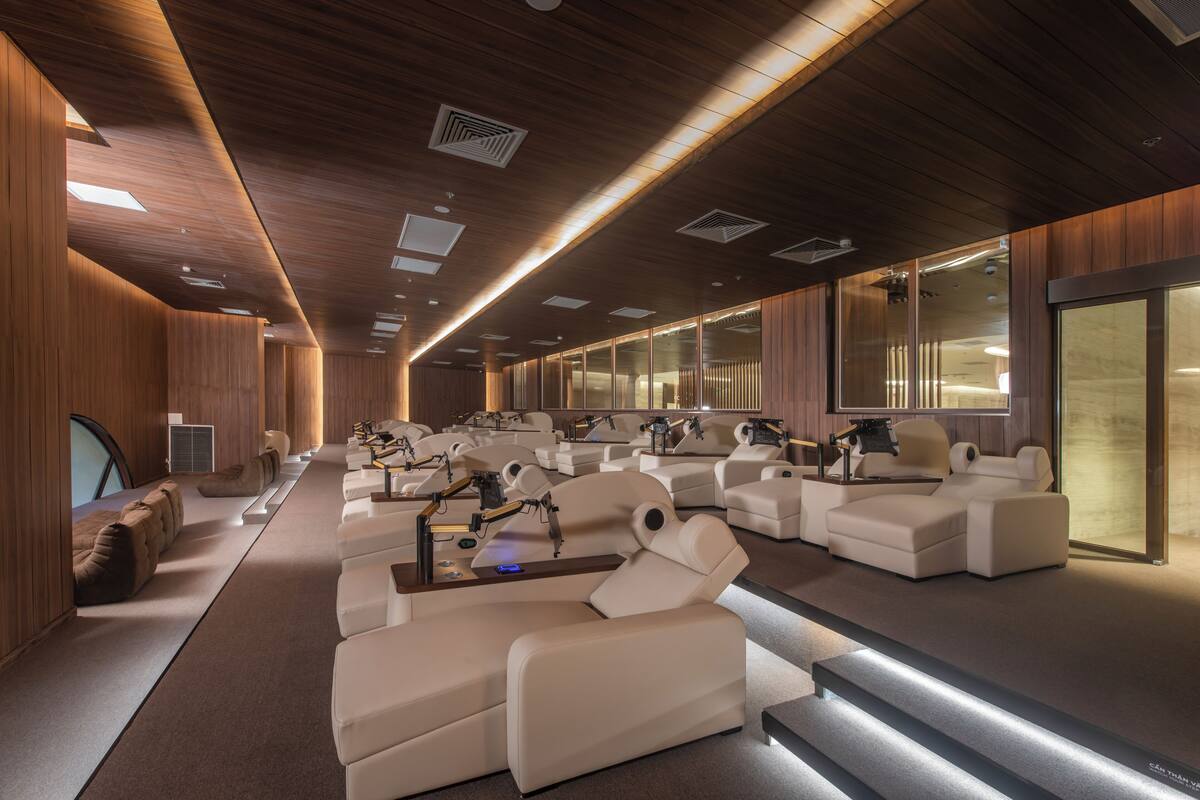 Een moderne spa met meerdere massagestoelen, houten lambrisering en een groot raam.