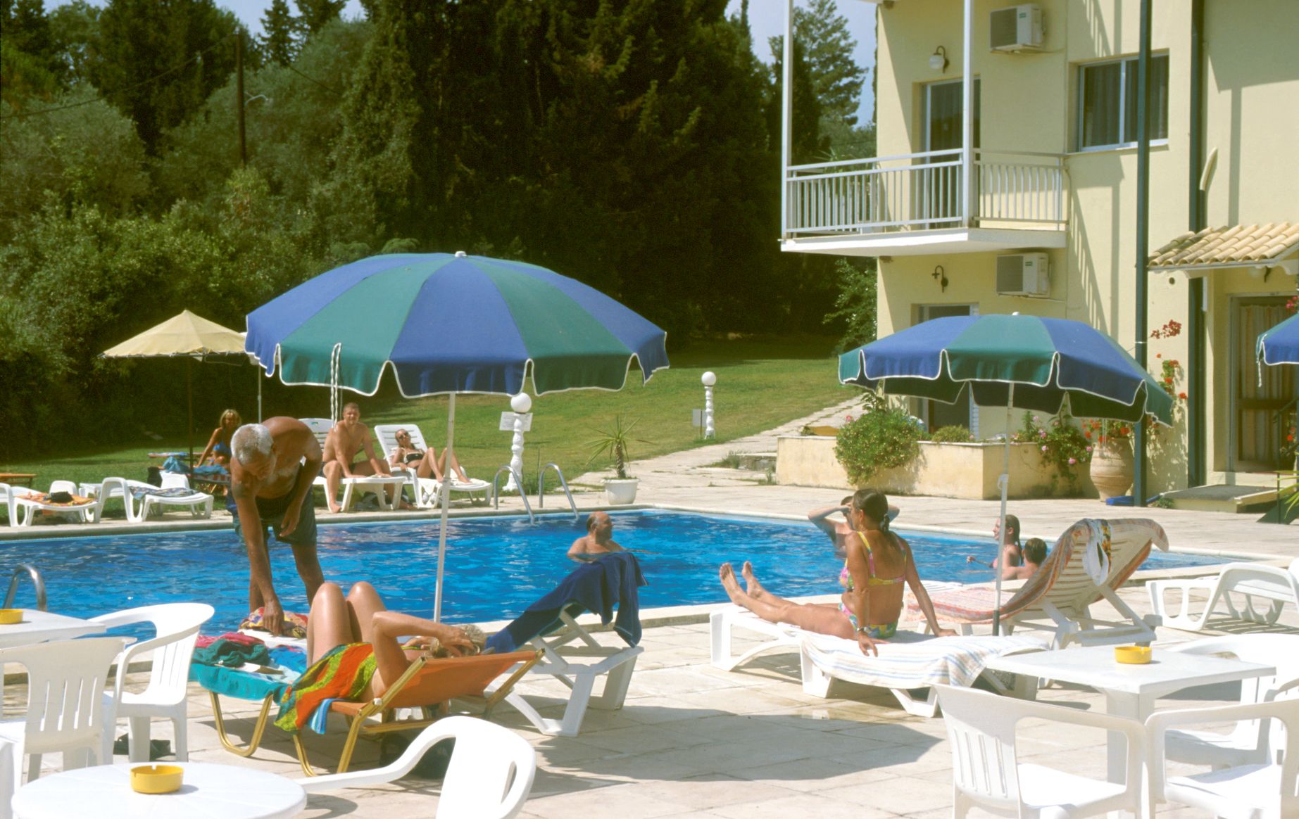 Un área de piscina con sillones de descanso y sombrillas.
