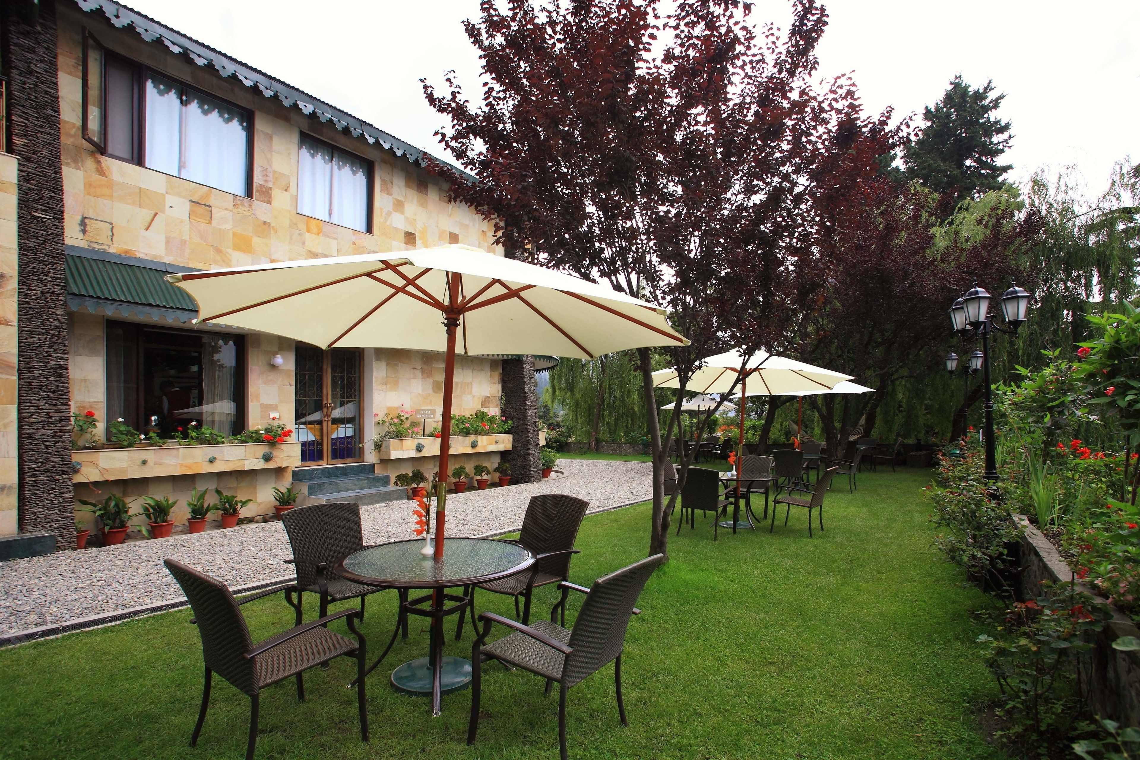 A patio area with outdoor seating, a stone building, and potted plants.