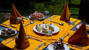 Una mesa redonda preparada para una comida, con diversos postres y utensilios.