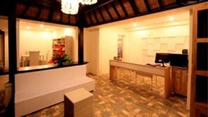 A reception area with a wooden ceiling, a reception desk, and a tiled floor. - The Tukad Villa (Seminyak)