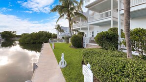 A waterfront property with a white building, a dock, and a sign indicating no swimming. - Coral Lagoon Resort Villas & Marina by KeysCaribbean (Marathon)