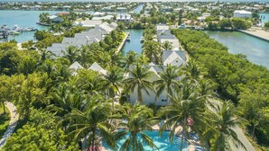 A resort with multiple buildings, a marina, and a swimming pool surrounded by palm trees. - Coral Lagoon Resort Villas & Marina by KeysCaribbean (Marathon)