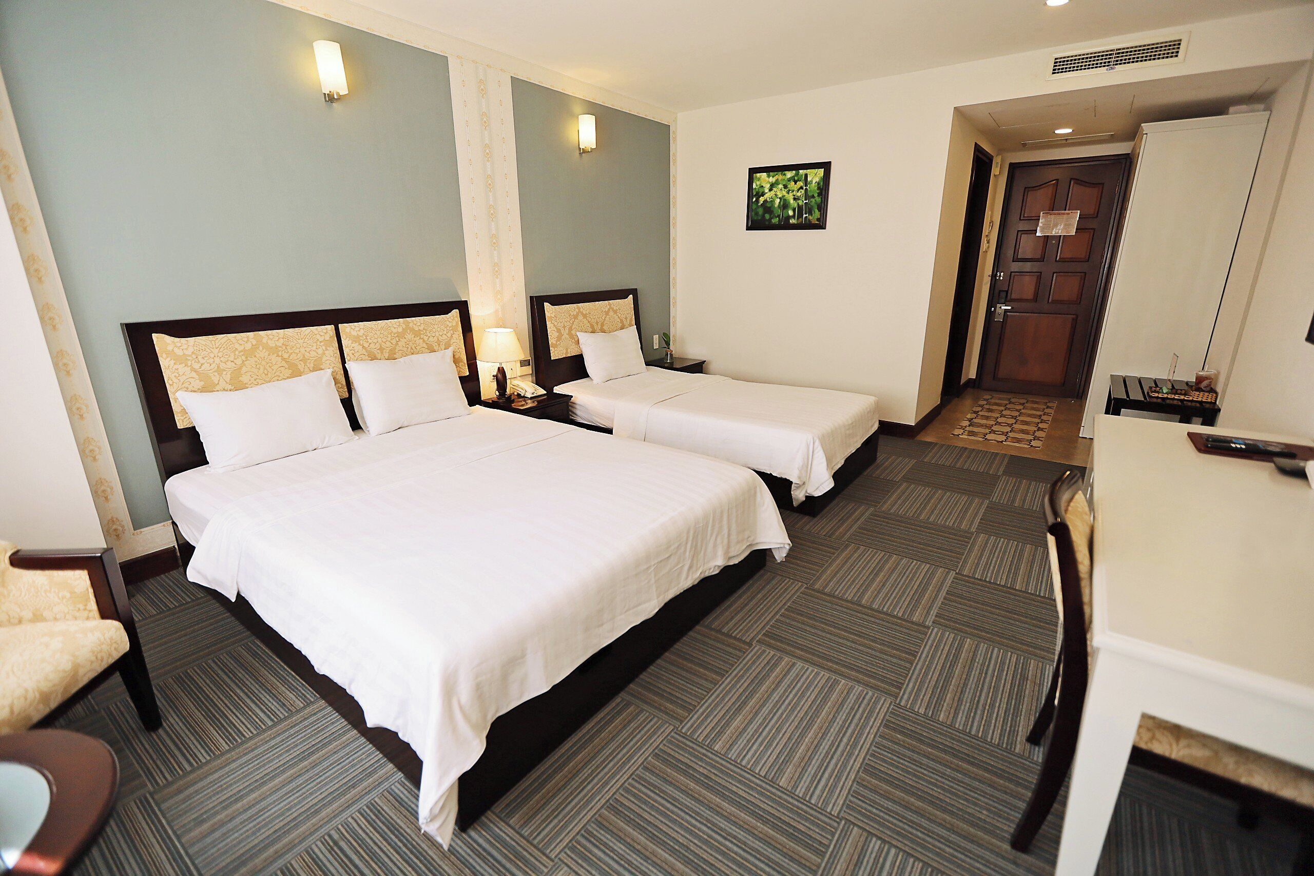 Habitación de hotel con dos camas, un escritorio y una silla.