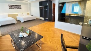 A hotel room with a bed, a small table with a teapot and cups, a wardrobe, and a bathroom with a mirror and curtains. - Dong Kinh Hotel (Ho Chi Minh City)
