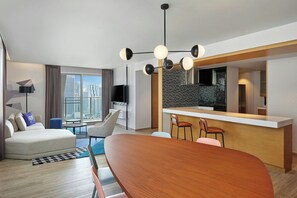 Suite, 2 habitaciones, vista a la ciudad (Ultra Savvy Suite) | Sala de estar | Televisión de 55 pulgadas con canales vía satélite 