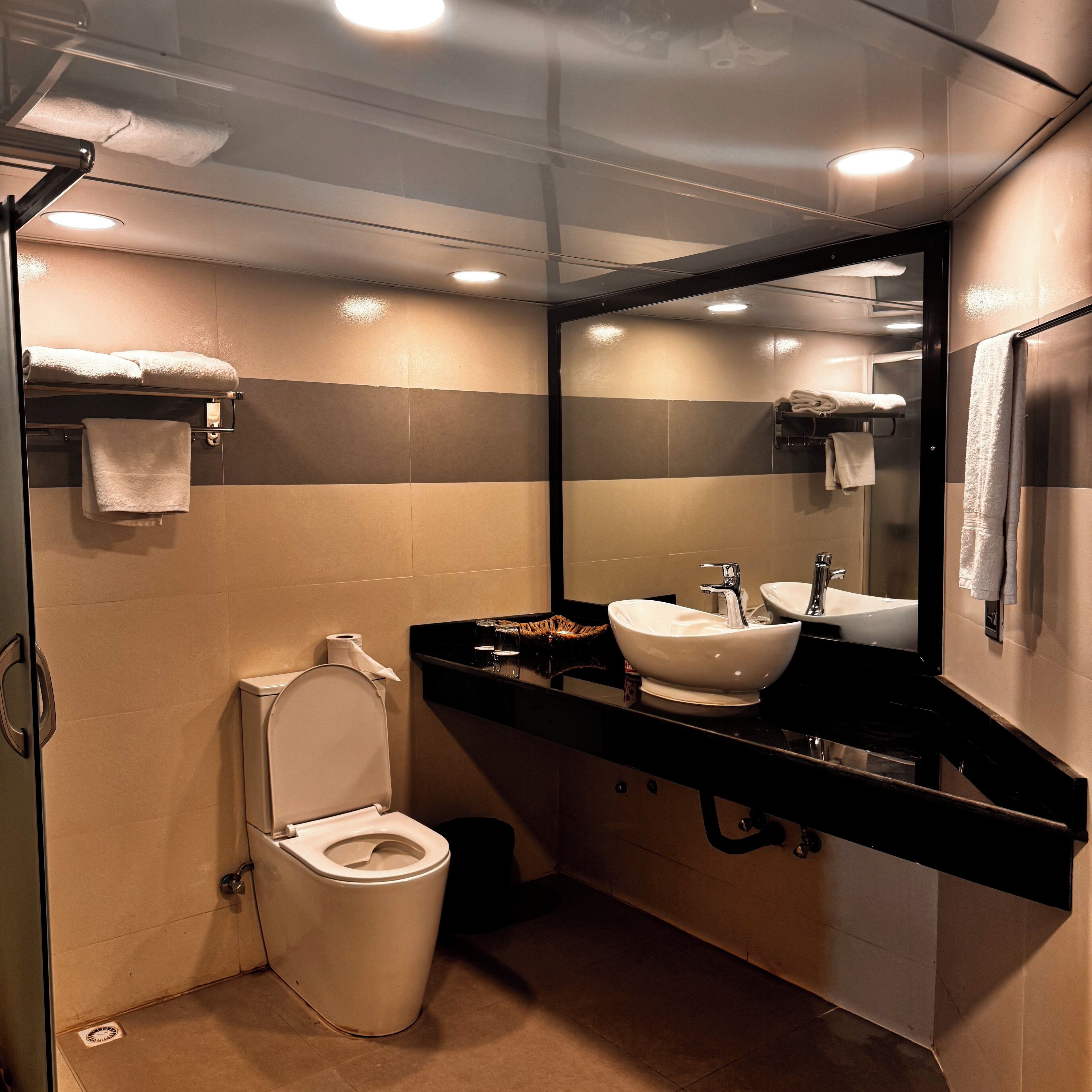 Une petite salle de bain comprenant des toilettes, un lavabo et un miroir.