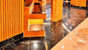 A modern hotel lobby with wooden paneling, a marble floor, and a staircase. - Presidential Hotel (Port Harcourt)