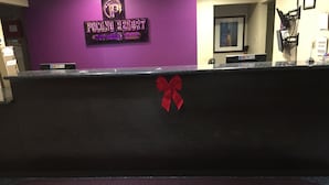 Un comptoir d’accueil au Pocono Resort Conference Center, avec un mur violet, un comptoir noir et un nœud rouge.