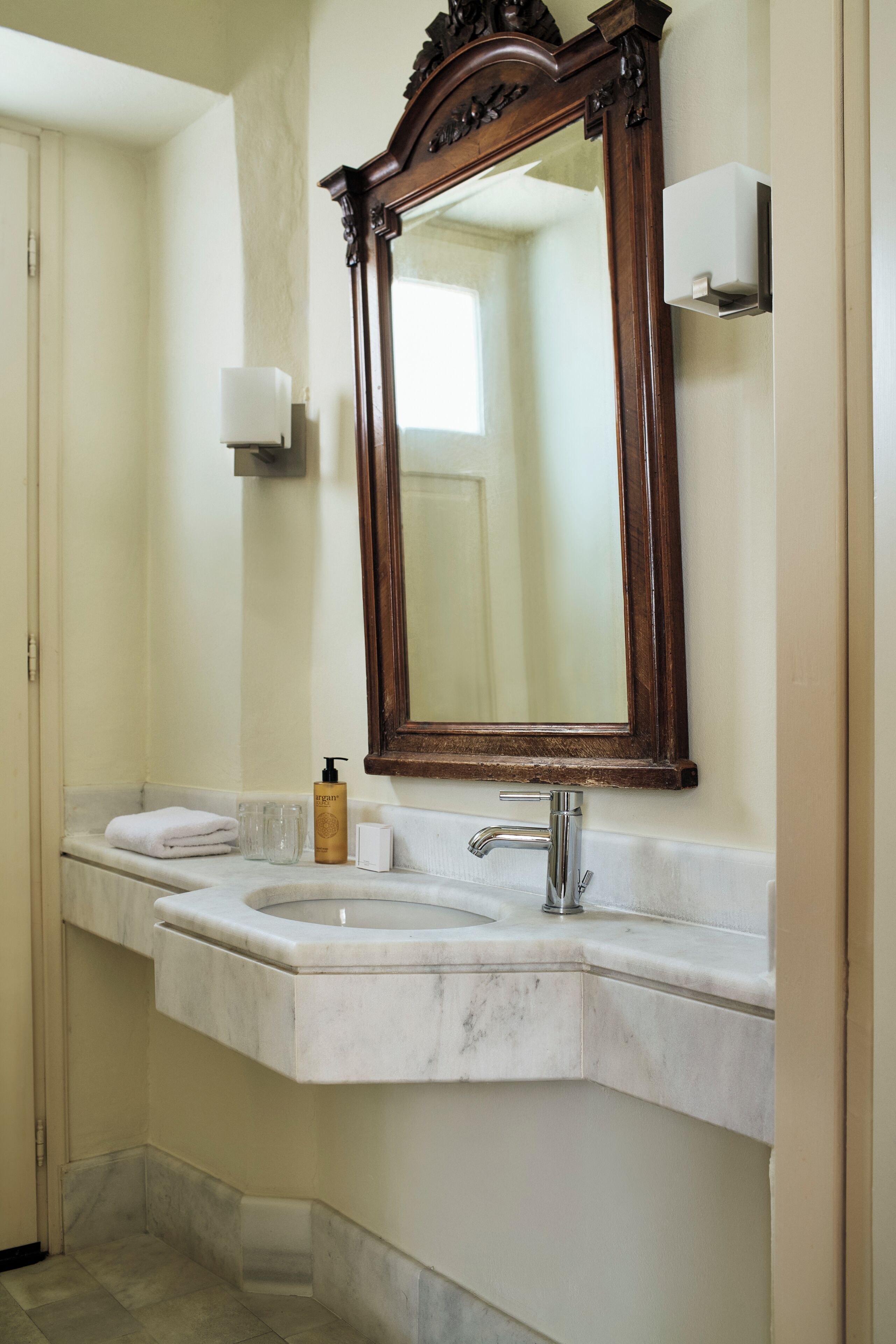 Une salle de bain avec deux lavabos, un grand miroir et un distributeur de savon.