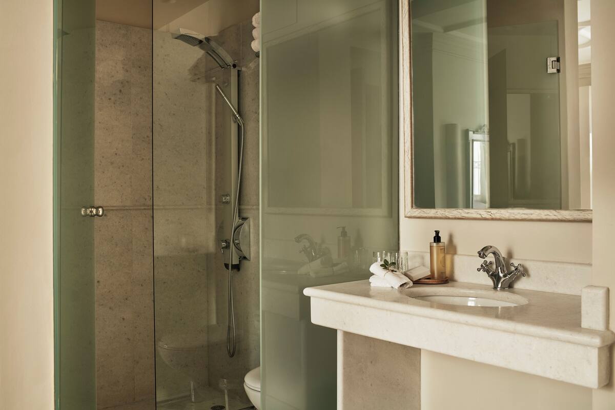 syrou melathron two bedroom sea view suite (main building) | bathroom | shower, free toiletries, hair dryer, slippers