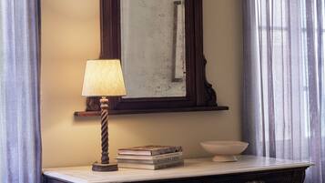 A dark wooden dresser with a mirror, a lamp, and a bowl on top.