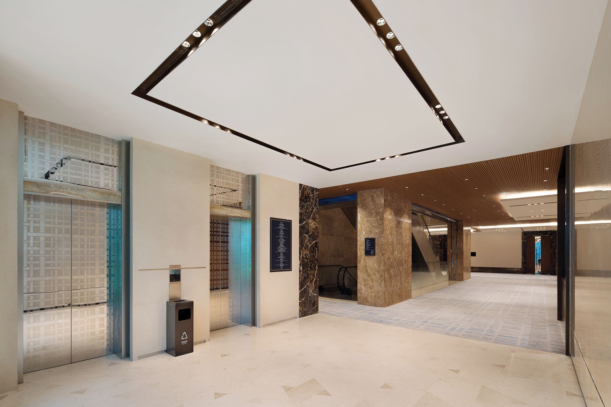 A modern interior with a geometric ceiling design, a patterned wall, and a clean, tiled floor.