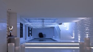 A modern interior with a central reflective pool, geometric wall patterns, and minimalist decor. - Sheraton Grand Beijing Dongcheng Hotel (Beijing)