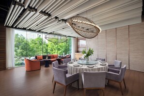 Un comedor moderno con una mesa redonda dispuesta para cuatro comensales, rodeada de sillas tapizadas.