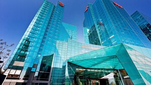 A modern glass building with a distinctive angular entrance and reflective surfaces. - Sheraton Grand Beijing Dongcheng Hotel (Beijing)