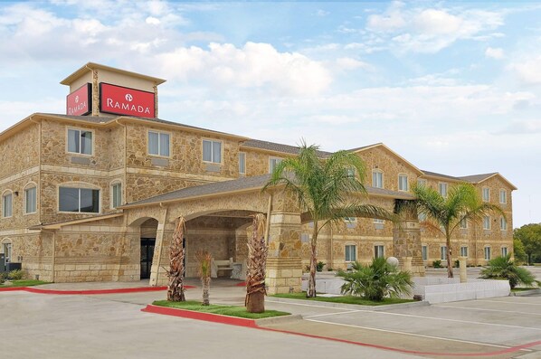 A multi-story stone building with a sign reading 'Ramada.'