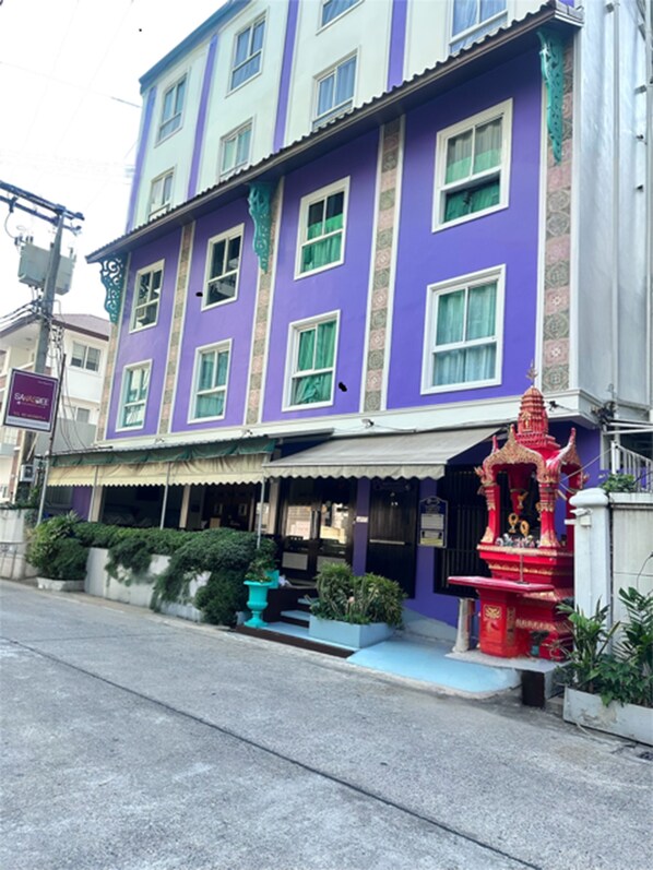 Stunning building with a vibrant purple facade, storefront, and outdoor seating area.