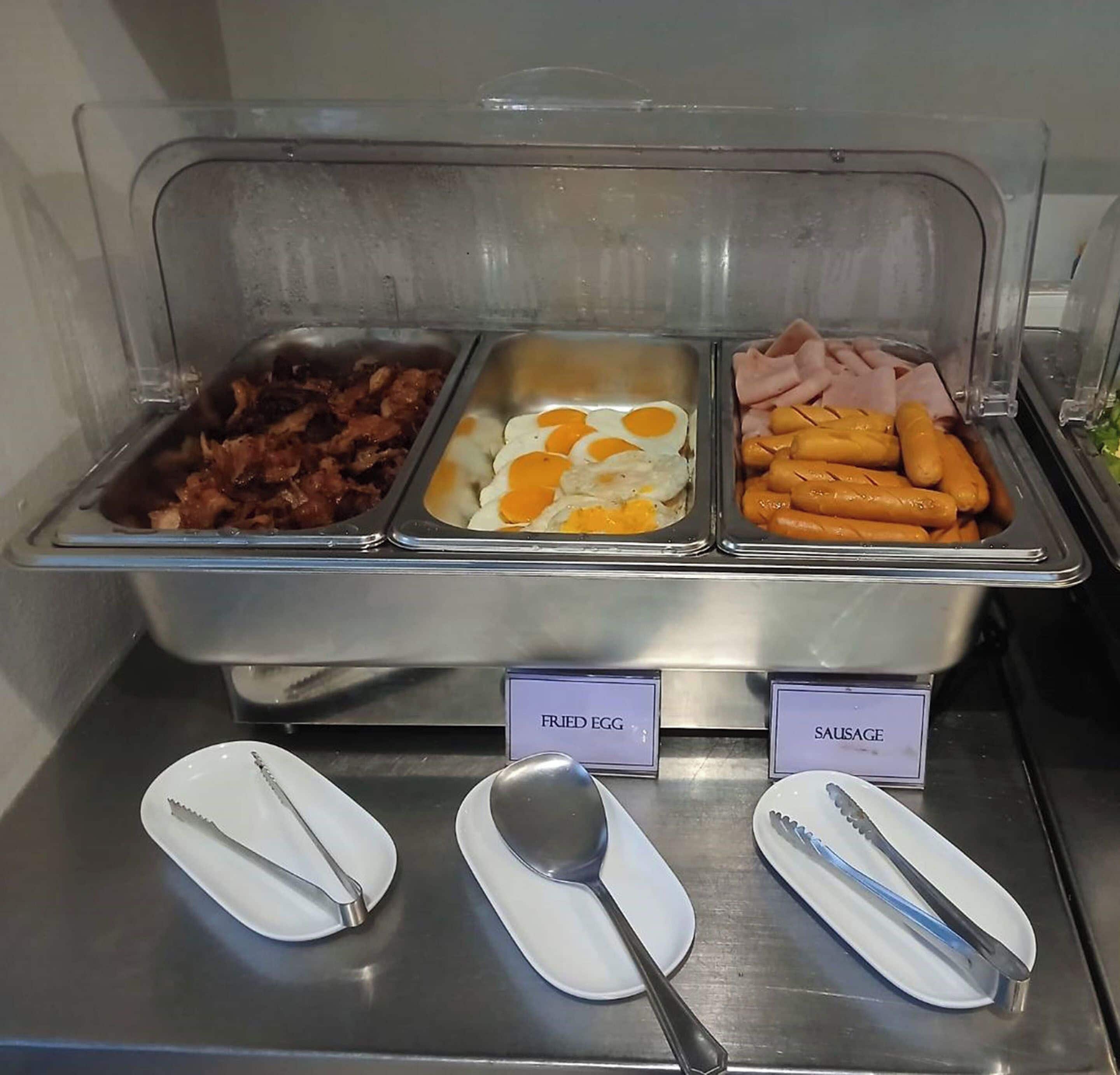 Ein Buffet mit ausgewiesenen Bereichen für Spiegeleier, Würstchen und Speck.
