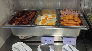 Ein Buffet mit ausgewiesenen Bereichen für Spiegeleier, Würstchen und Speck.