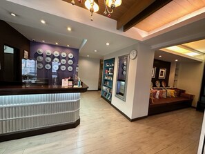 Welcome to our reception area, featuring a comfortable seating area with a sofa and table, a reception desk, and decorative circular accents.