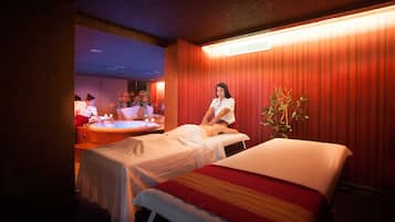 Relax in a serene spa setting with a massage table and hot tub.