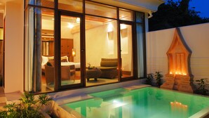 A modern house with a glass-enclosed living area, a pool, and a stone fireplace. - Montien House Chaweng Beach Resort (Koh Samui)