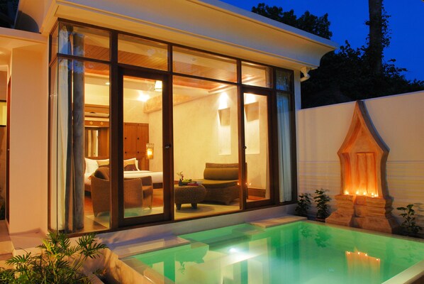 A modern house with a glass-enclosed living area, a pool, and a stone fireplace. - Montien House Chaweng Beach Resort (Koh Samui)