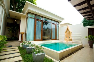 A modern house with a swimming pool, a wooden gazebo, and potted plants.