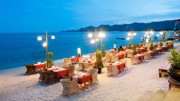 A beachfront restaurant with outdoor seating, tables, and chairs, overlooking the sea. - Montien House Chaweng Beach Resort (Koh Samui)