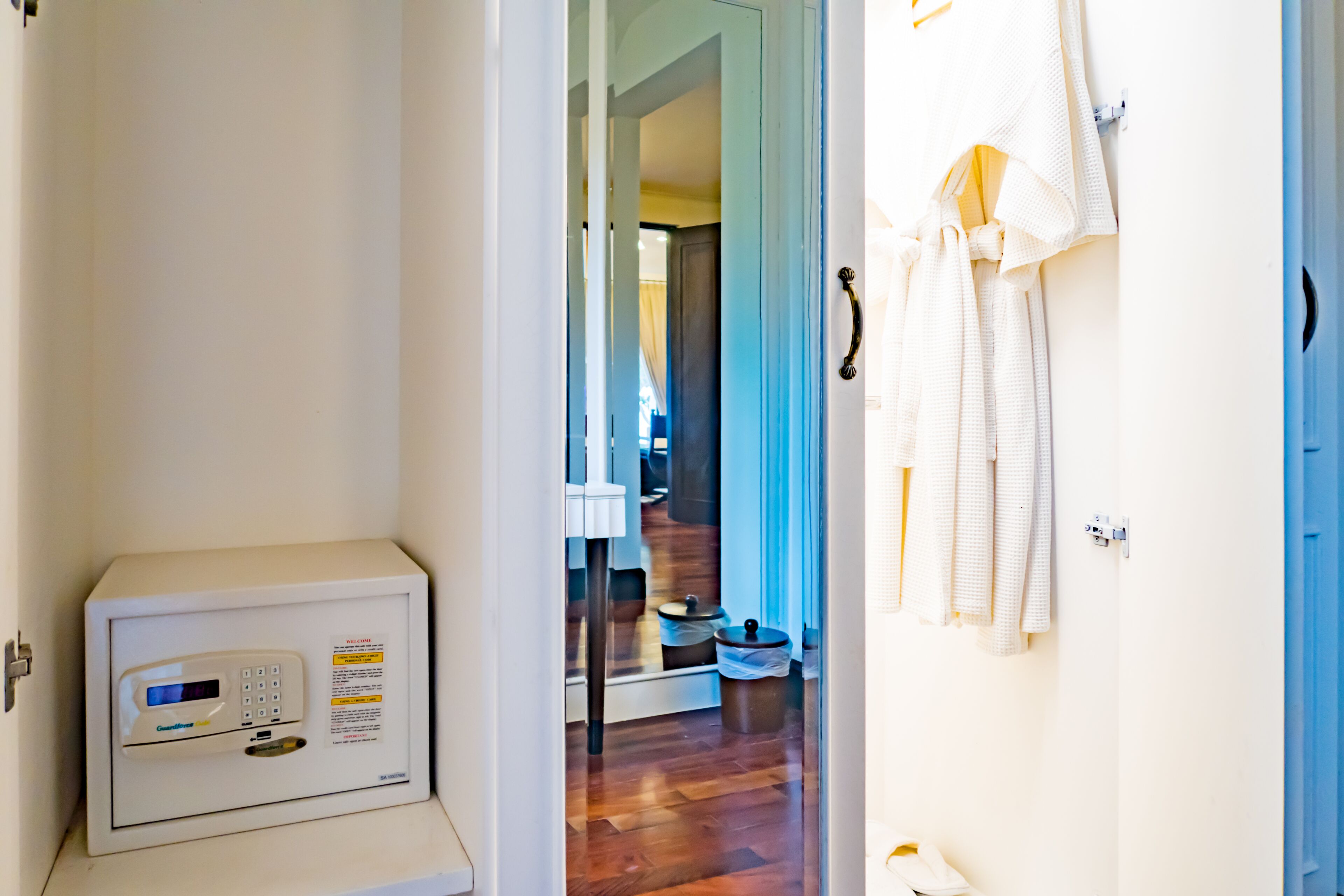 A hallway with a microwave, a blue door, and a rack of towels.