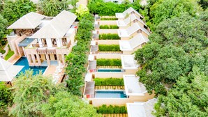 Resort com várias piscinas, incluindo uma piscina central ampla, e vegetação exuberante.