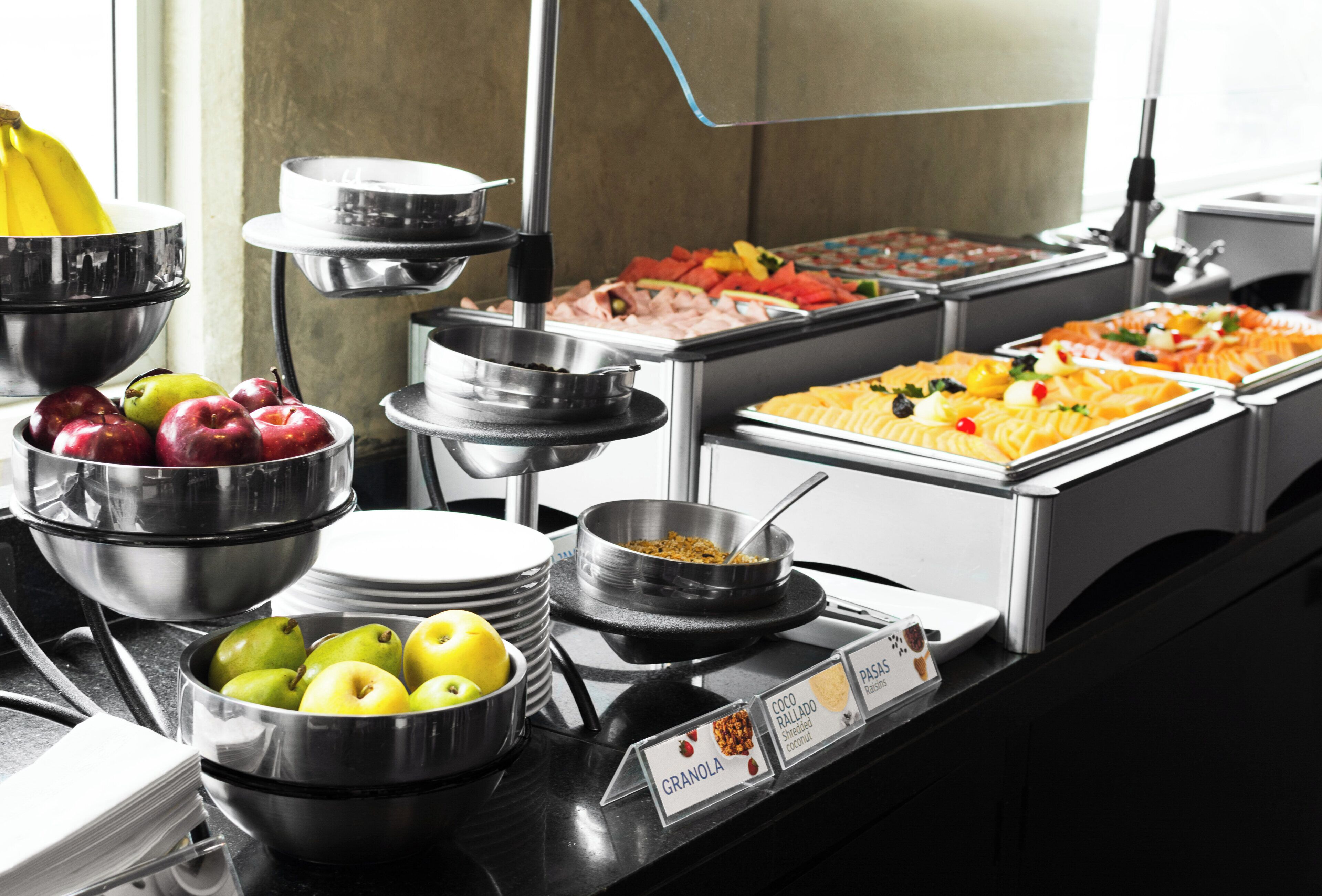 A buffet with various food options including fruits, vegetables, and cereals.