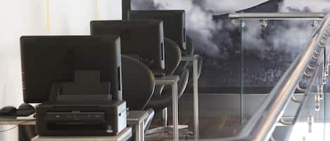 A row of HP computers on desks with a mountain view through a glass partition.