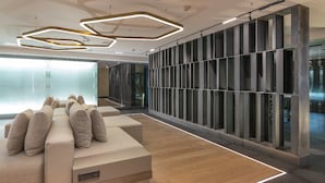 Un intérieur moderne avec un espace salon, un mur en verre et un plancher en bois.