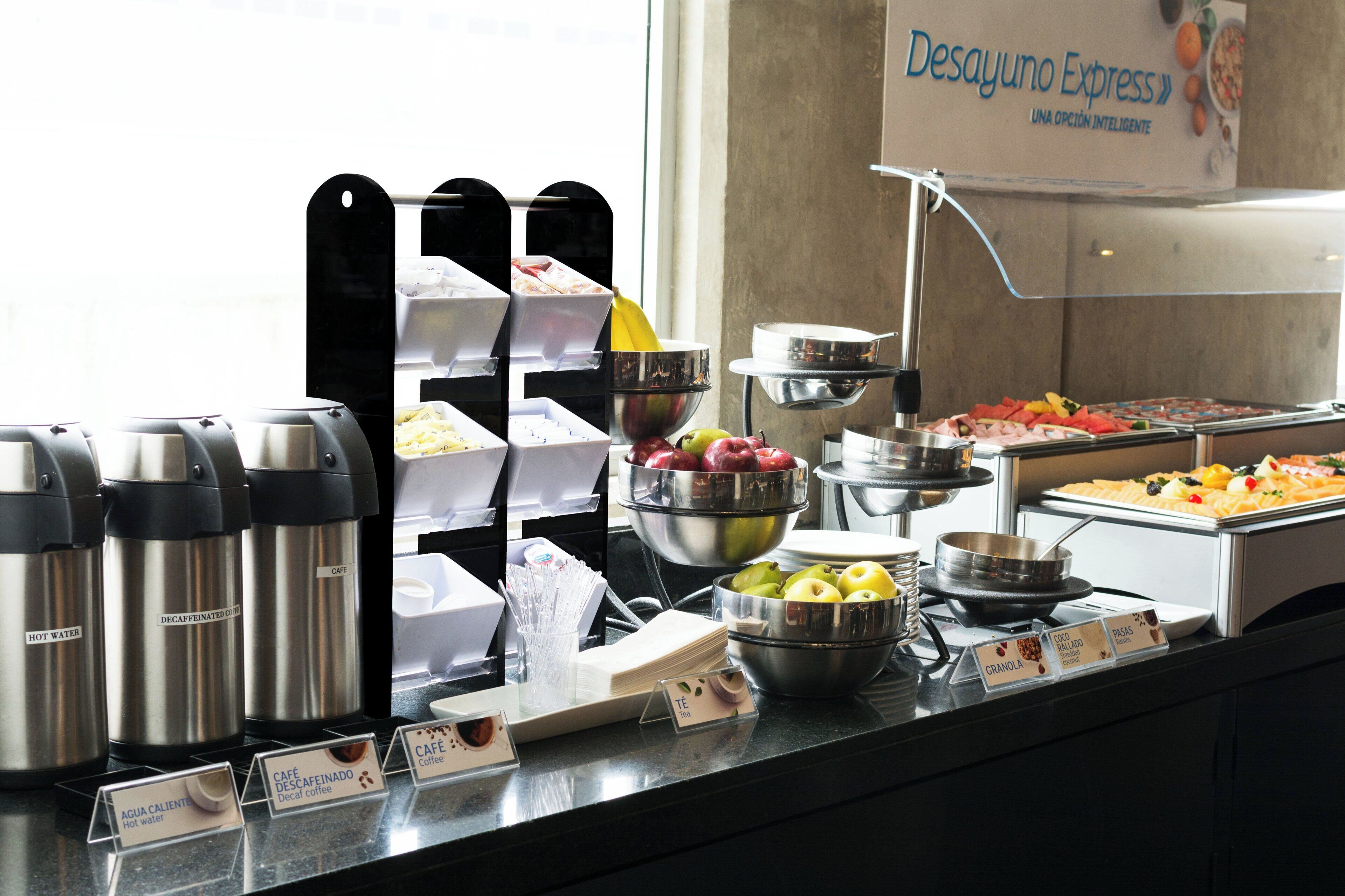 A buffet with various food options and labeled beverage dispensers.
