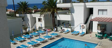 حمّام سباحة خارجي، مظلات على حمّام السباحة، مقاعد للتشمس