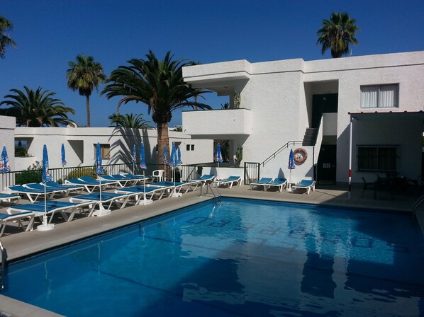 Piscine extérieure, parasols de plage, chaises longues
